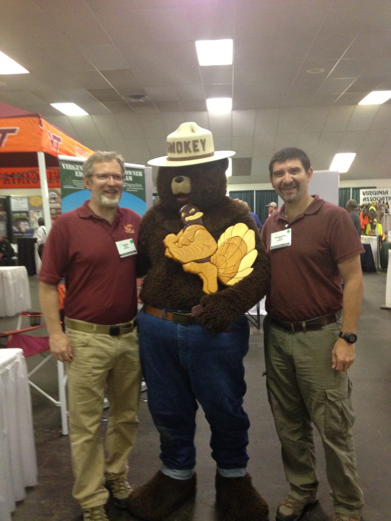 Drs. Brian Bond and Henry Quesada enjoy Smokey Bear's visit to the SBIO Department booth.